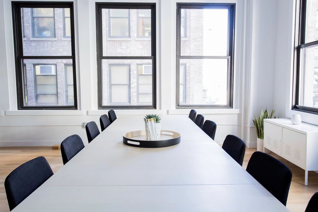 A meeting room with a long table and chairs